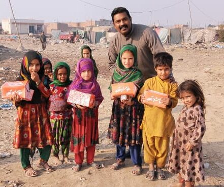 Vital Solutions Work in Pakistan, Vital Solutions Pakistan National Director, Asher Aziz with a group of children, outdoors.