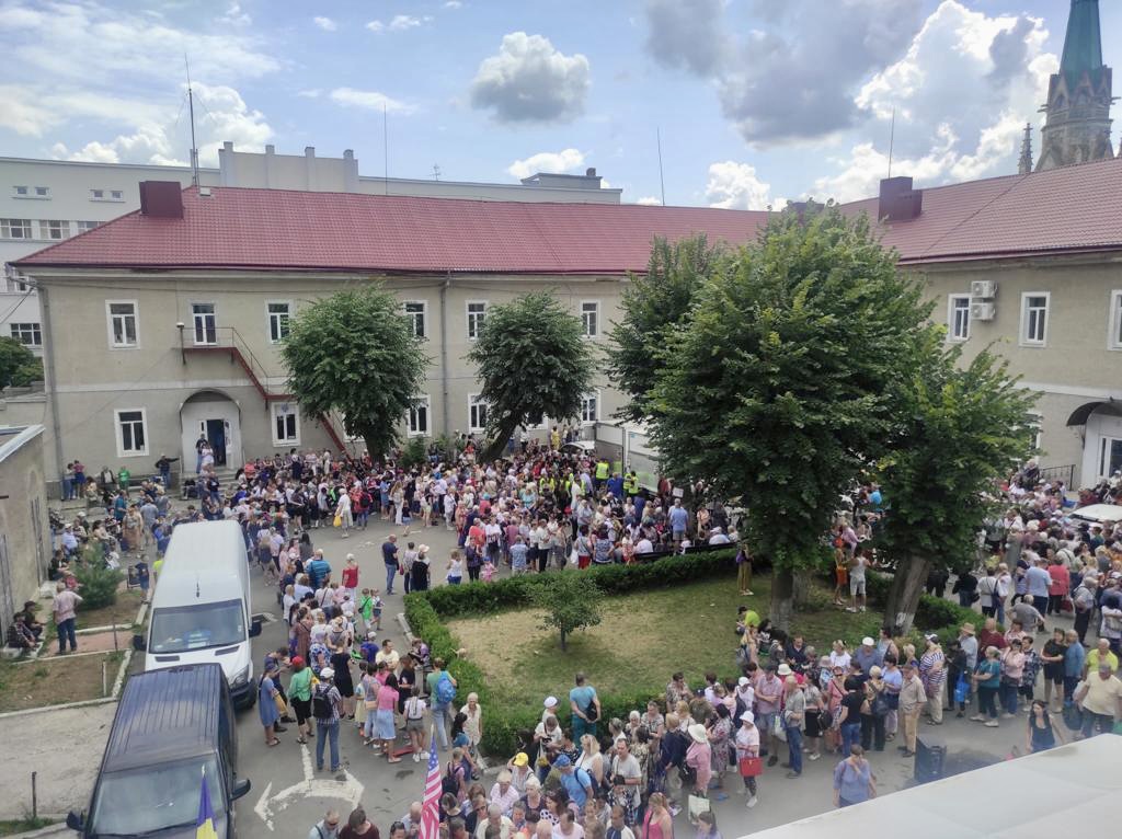 Vital Solutions Ukraine Refugee Relief, a mass of people waiting outside in a courtyard for food and supplies.
